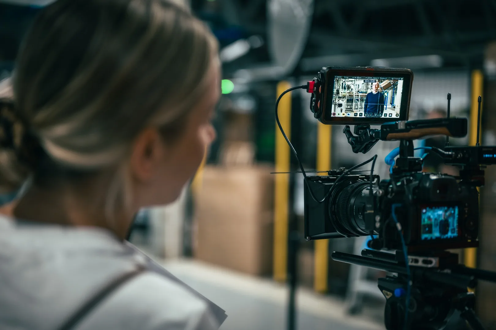 Over-the-shoulder view of Malwina watching a director’s monitor during a shoot at a Nomagic customer site.